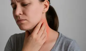 Donna con mano sul collo, evidenziando un'area arrossata e un'espressione di dolore sotto la mandibola.