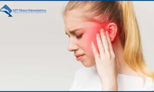 Donna con dolore alla tempia, che indica i sintomi dell'infiammazione temporo-mandibolare.