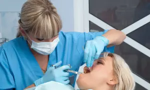 Dentista somministra anestetico per mal di denti a una paziente.