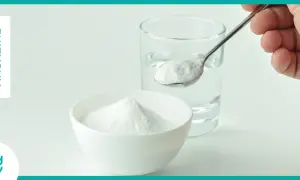 Un cucchiaino di bicarbonato pronto per essere sciolto in un bicchiere d'acqua. Un rimedio casalingo per diversi usi.