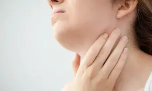 Mano che tocca il collo, forse per sentire i linfonodi sottomentali ingrossati.