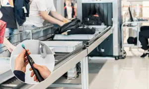 Spazzolino elettrico in aereo, pronto per essere messo nel bagaglio a mano. La sicurezza aeroportuale controlla borse e zaini.