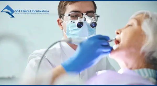 Dentista con lente d'ingrandimento esamina la bocca di un'anziana, garantendo un'accurata igiene orale anziani.