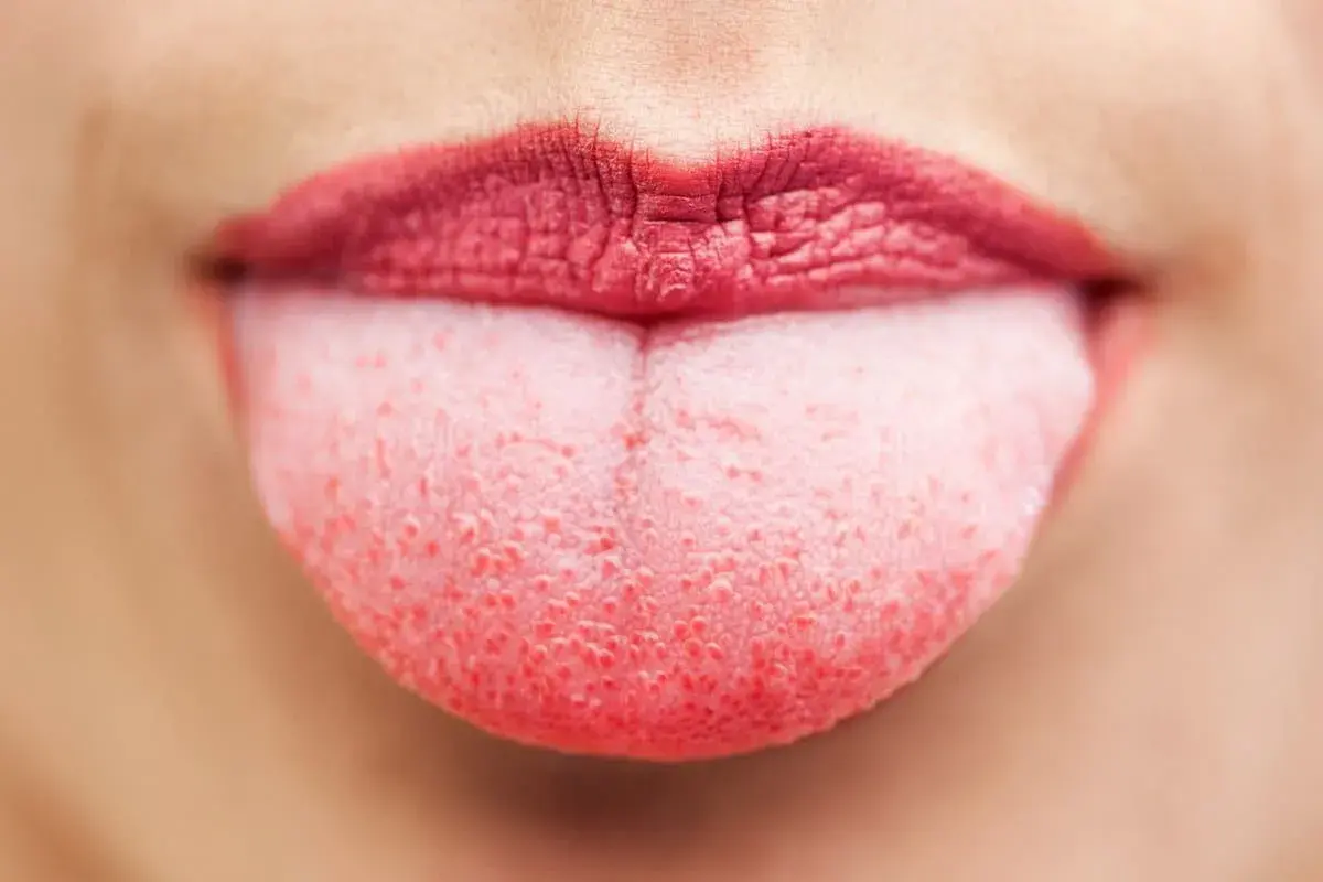 Lingua rosa con labbra rosse, mostrando le papille gustative pronte a sentire ogni sapore.