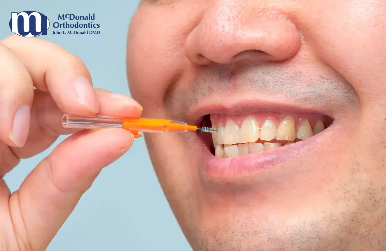 Uomo usa una forcella tendifilo interdentale per pulire tra i denti.