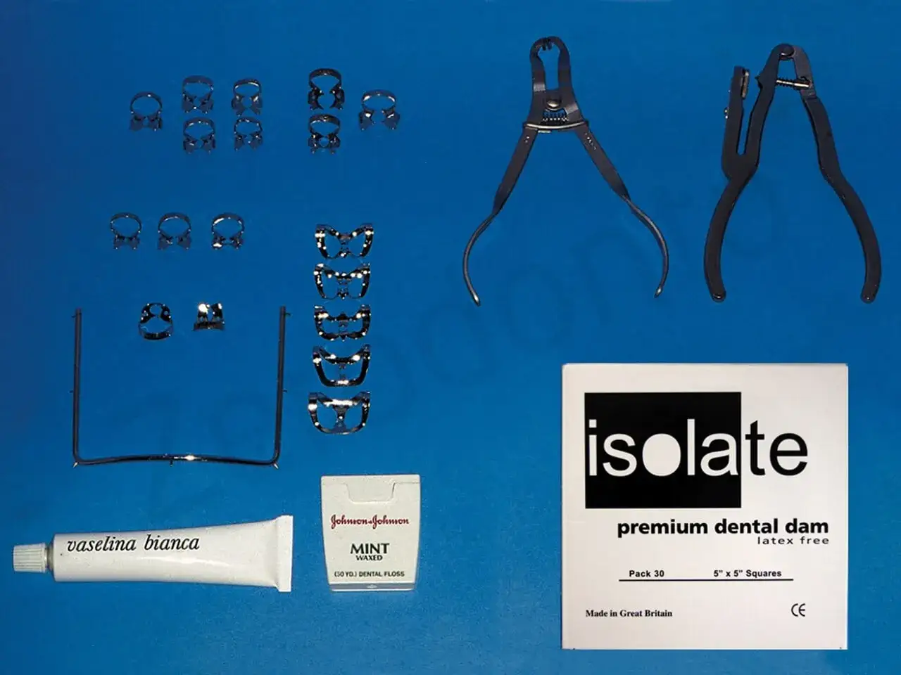 Kit per diga di gomma dentista: morsetti, pinze, vaselina, filo interdentale e confezione di diga in lattice.
