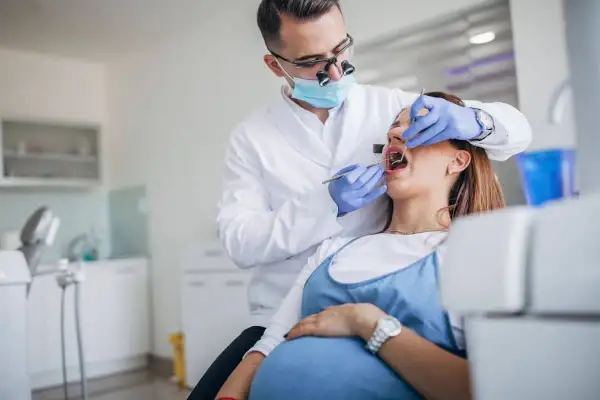 Dentista visita una donna incinta per il mal di denti in gravidanza.