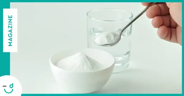 Un cucchiaino di bicarbonato pronto per essere sciolto in un bicchiere d'acqua. Un rimedio casalingo per diversi usi.